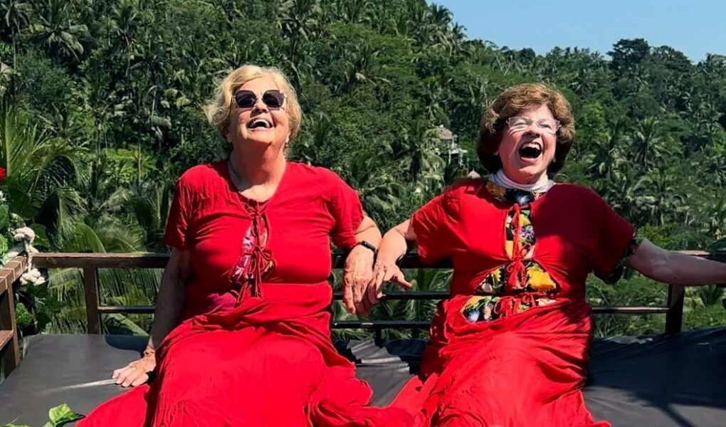 Ellie Hamby and Sandy Hazelip, better known as TikTok Traveling Grannies, having a laugh while dressed in red, and swinging on a gigantic swing in Bali, Indonesia.
