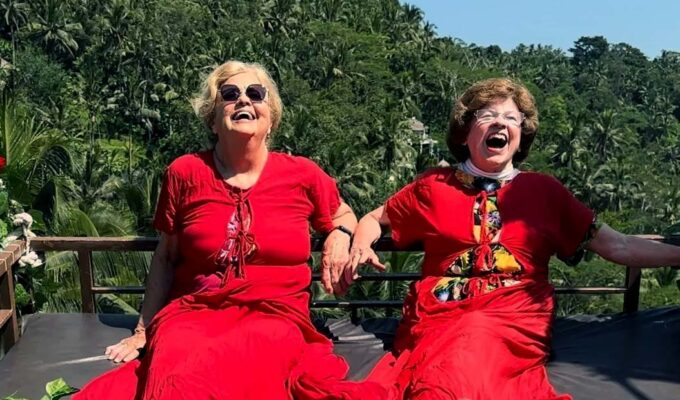 Ellie Hamby and Sandy Hazelip, better known as TikTok Traveling Grannies, having a laugh while dressed in red, and swinging on a gigantic swing in Bali, Indonesia.