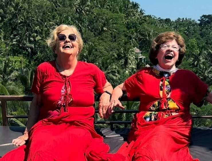 Ellie Hamby and Sandy Hazelip, better known as TikTok Traveling Grannies, having a laugh while dressed in red, and swinging on a gigantic swing in Bali, Indonesia.