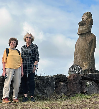 Sandy Hazelip and Ellie Hamby, also known as TikTok Traveling Grannies, in front of Moai statue on Easter Island, Chile.