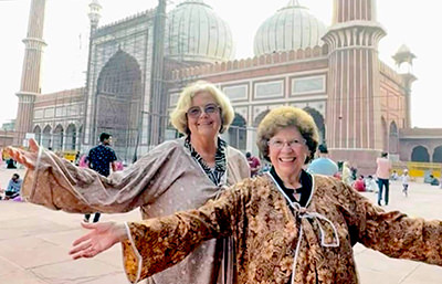 TikTok Traveling Grannies Ellie Hamby and Sandy Hazelip posing with arms wide open.