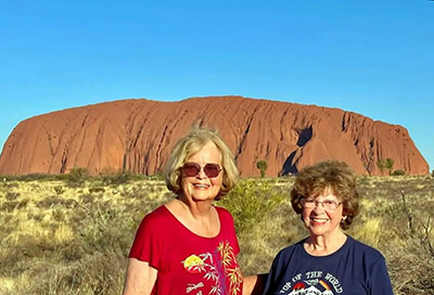 TikTok Traveling Grannies Ellie and Sandy in front of Uluru rock in Australia.