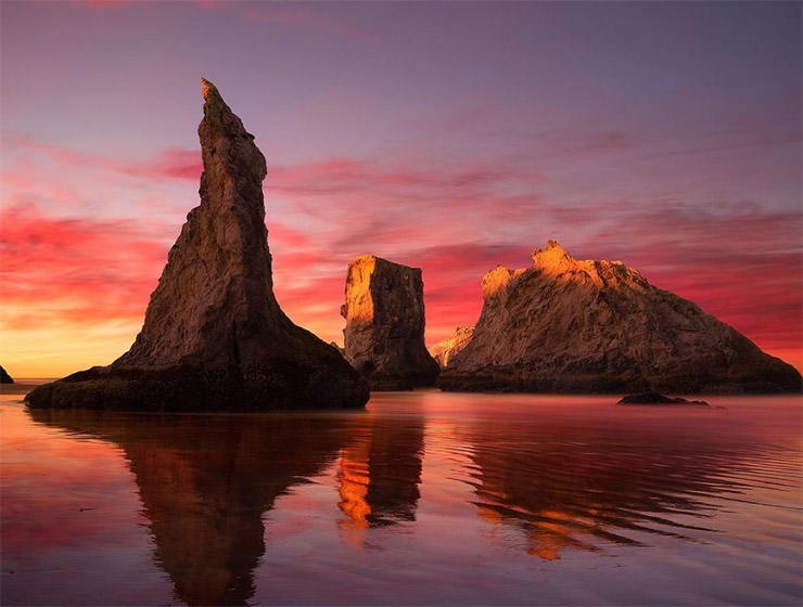 Wizard's Hat rock, an "island" that looks like a witch's hat, shot at sunset, with colorful sky; photo by Stephen Brown.