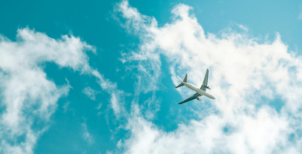 Frog's eye view of a plane flying below the skies; aviation industry is back in 2023, and these are the trends shaping its future; photo by Terra, Unsplash.