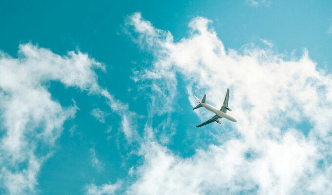 Frog's eye view of a plane flying below the skies; aviation industry is back in 2023, and these are the trends shaping its future; photo by Terra, Unsplash.