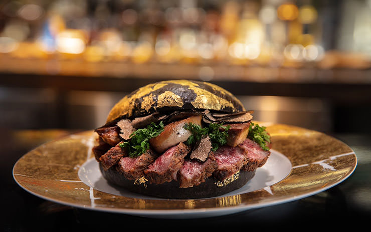 Black Gold Burger, the expensive item of room service at Post Oak Hotel in Houston, USA, made of Wagyu beef, foie gras, and black truffle, in a caviar-infused black and 24K gold brioche bun. The burger costs 1,600 dollars.
