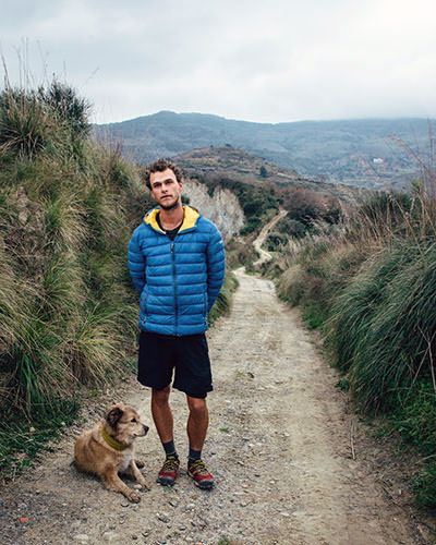 Tom Turcich posing on a dirt road with his dog Savannah, on Sicily, Italy, during their epic walk around the world.