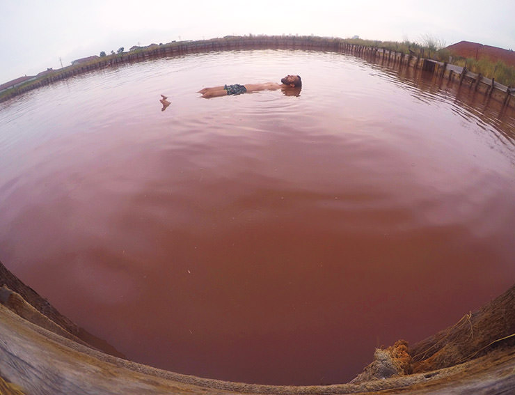 Travel blogger Ivan Kralj floating in the pink-hued Burgas Salt Pans feeding from Lake Atanasovsko in Bulgaria; photo by Ivan Kralj.