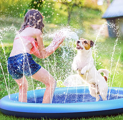 Little girl and a dog splashing in a dog pool by Peteast, one of the summer must-haves for a furry friend; available on Amazon.