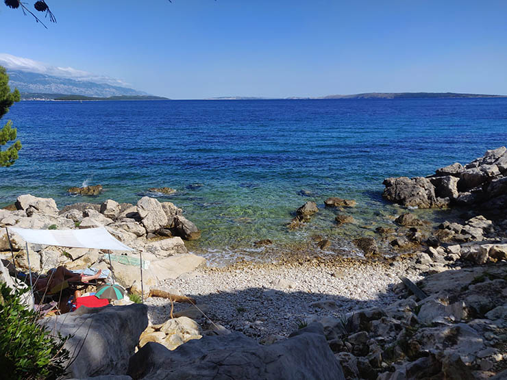 Pebbled naturist beach in Kandarola Bay, outside of the concession zone that covers FKK Kandarola Beach, Rab, Croatia; photo by Ivan Kralj.