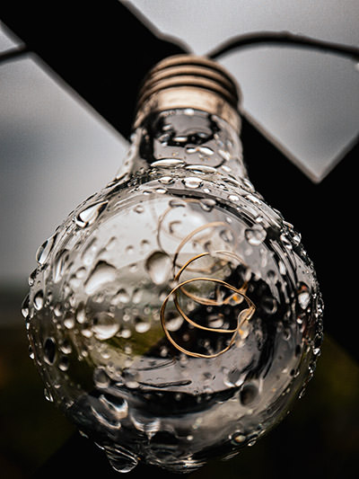 Droplets of water on a lightbulb, concept of energy consumption; photo by Nikola Tomašić, Unsplash.