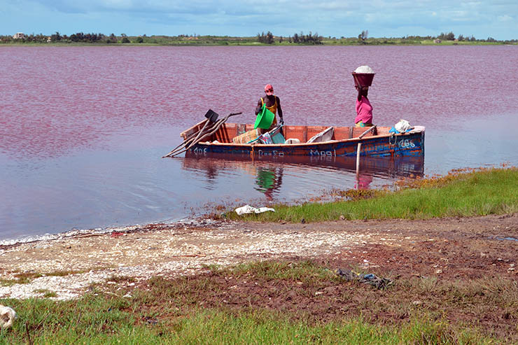 Man and woman carrying salt out of the Lake Retba or Lac Rose, the pink lake of Senegal, Africa; photo by La Mireia.