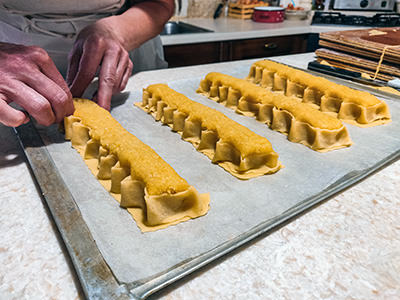 Diligent hands of Ružica Ribarić lacing golden bars of Rab cake