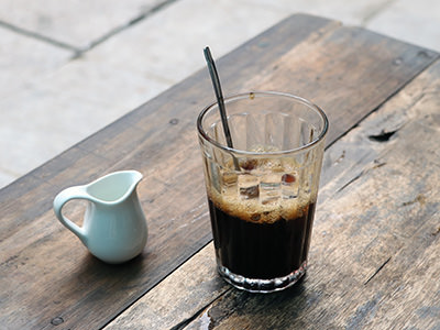 Vietnamese coffee served in a glass, with condensed milk on the side; photo by Hoang Thanh, Unsplash.