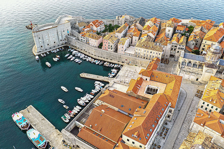 Aerial view of a harbor in the historic town of Dubrovnik, one of the favorite destinations for couples planning a honeymoon in Croatia; photo by Mana5280, Unsplash.
