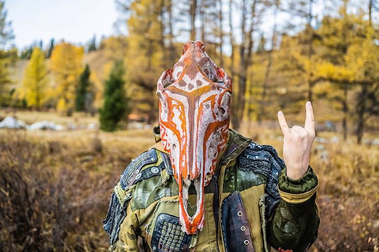 Person with painted animal skull as a mask posing at MadWay Rally in Altai Mountains.