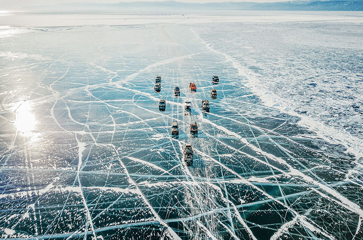 Drone view of the MadWay Rally convoy on frozen Lake Baikal in Russia, Mad Max-inspired race in the remote regions of the world.