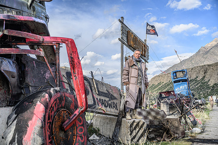 Alexey Gubarev, Cypriot tech entrepreneur and organizer of MadWay Rally, standing on the car and construction debris in Kyrgyzstan.