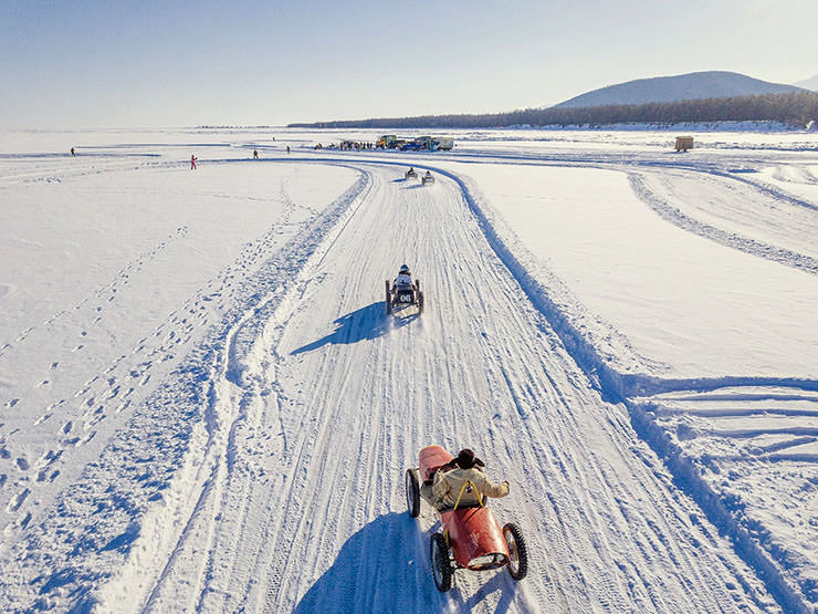 Mini-carts racing in the snowy landscape of the frozen Lake Baikal, during the MadWay Rally.