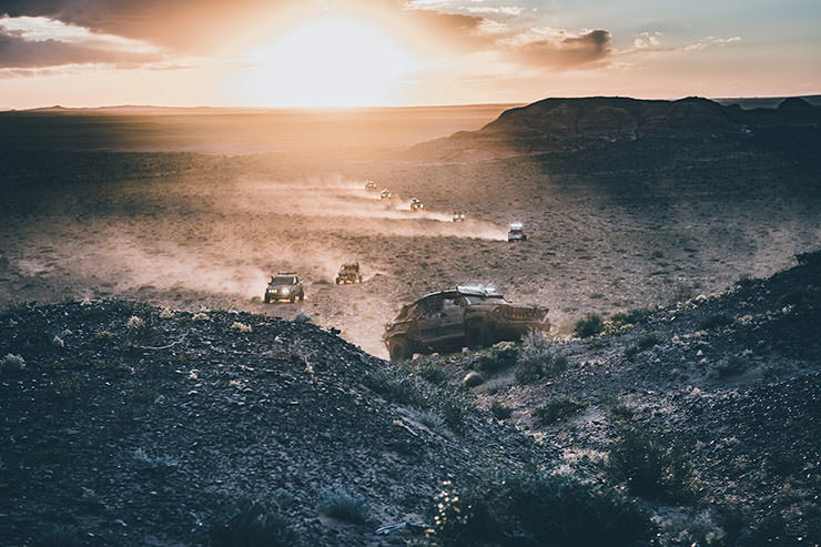 Cars during the sunset in a dusty landscape of Mongolia, during the MadWay Rally, Mad Max-inspired event in the modern "Wasteland".