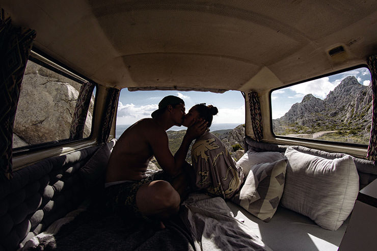 A couple kissing inside a van near Tulove Grede cliffs in Velebit mountain. Roadtrip in a rented van is a great idea for a honeymoon in Croatia; photo by Marta Rastovac, Unsplash.