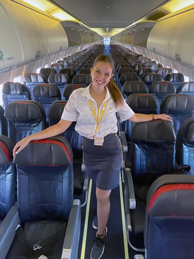 Josefina Macchi, Flybondi flight attendant standing in the aisle of the plane; she was said to lose weight when she applied for the job at Emirates; private album.