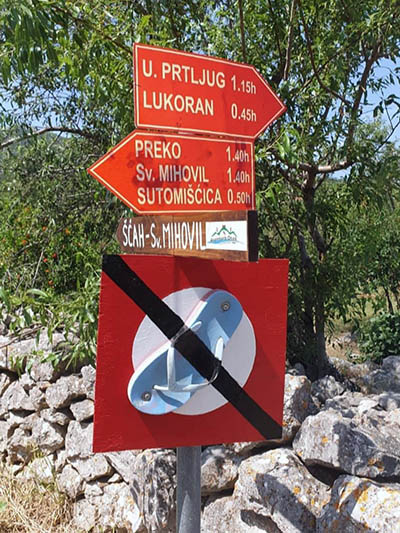 "No flip-flops" sign on Ugljan Island, Croatia, posted by Croatian Mountain Rescue Service as part of their humorous safety marketing for tourists.