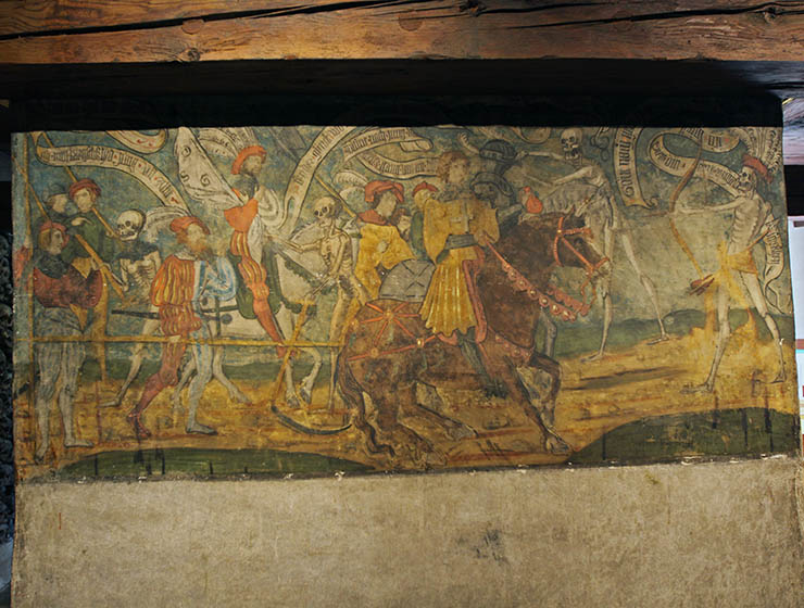 Danse Macabre fresco in Beinhaus Leuk, Renaissance artwork showing skeletons attacking men on horses who cannot escape Death even with the help of an armor or bribe; photo by Ivan Kralj.