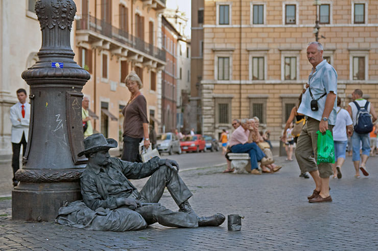 Human statue performer in Rome, Italy, resting on a square, during riposo or siesta; photo by Roberto Ventre.