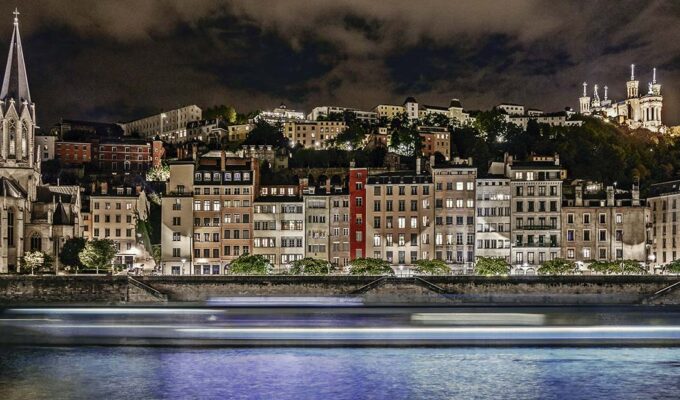 Night panorama of Lyon's Saint-Georges neighborhood, with a touristic boat passing by; photo by Free Nomad, Unsplash.