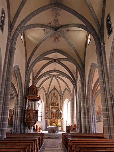 Central nave of St. Stephan's Church in Leuk, Switzerland, with the view of the altar and an intricately carved pulpit; photo by Ivan Kralj.