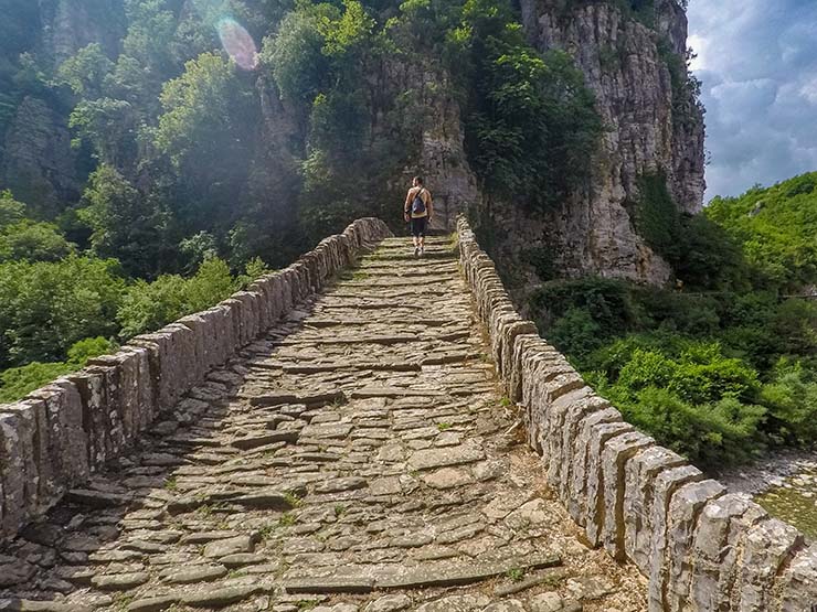 Travel blogger Ivan Kralj climbing over the Kokkorou stone bridge of Zagori, Epirus, in northwestern Greece; photo by Nikos Samartzis.