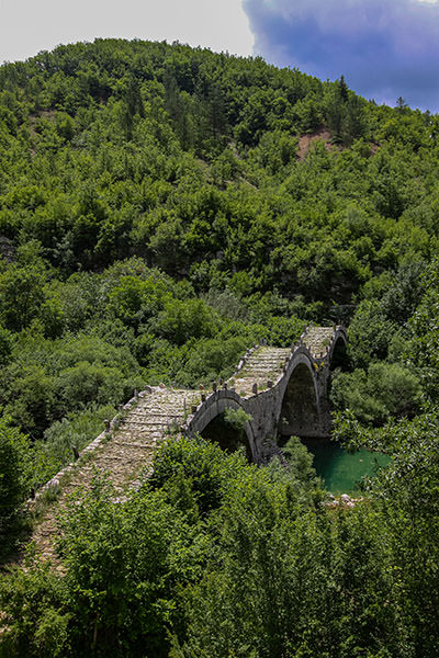 Caterpillar-resembling three-arch stone bridge of Plakidas in green landscape of Zagori, Epirus, Greece; photo by Ivan Kralj.