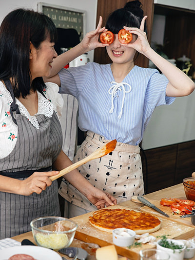 Women having fun during a pizza-making cooking class; photo by Katerina Holmes, Pexels.