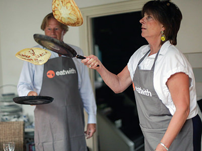 Eatwith Amsterdam, participants of Fusina's baking class flip their Dutch pancakes; photo by Eatwith.