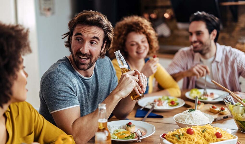 A group of happy people eating together, social dining; photo by Drazen Zigic, Freepik.