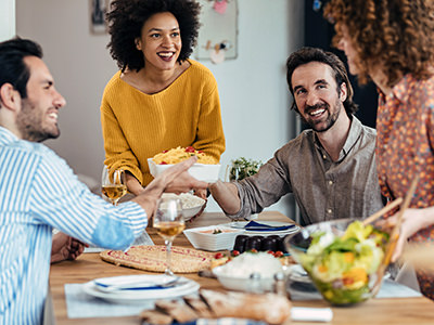 Guests eat with their host in relaxed social dining atmosphere; photo by Drazen Zigic, Freepik.