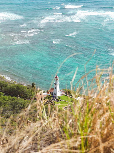 Sea waves and a lighthouse in Hawaii, USA, one of the best places to travel in 2024; photo by Faith Lehman, Unsplash.
