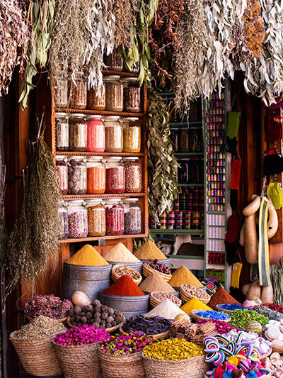 Colorful market stall with spices and candies in Marrakesh, Morocco, one of the top places to travel in 2024; photo by Laura C, Unsplash.