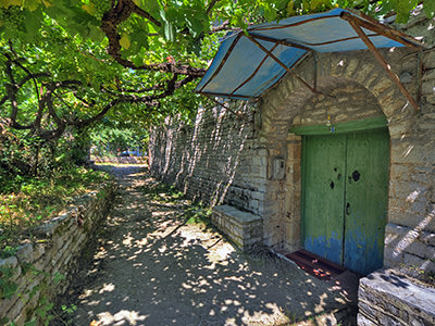 A street in the stone village of Vikos, Zagorochoria, with shade-providing vines; phoot by Massonth.