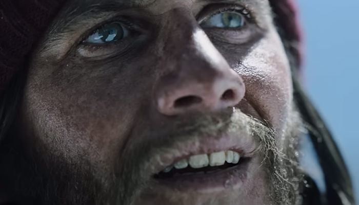 Close-up of Agustin Pardella, playing Fernando Nando Parrado in Netflix movie "Society of the Snow"; stranded in the mountain, his lips are cracked due to dehydration and exposure to harsh environment.
