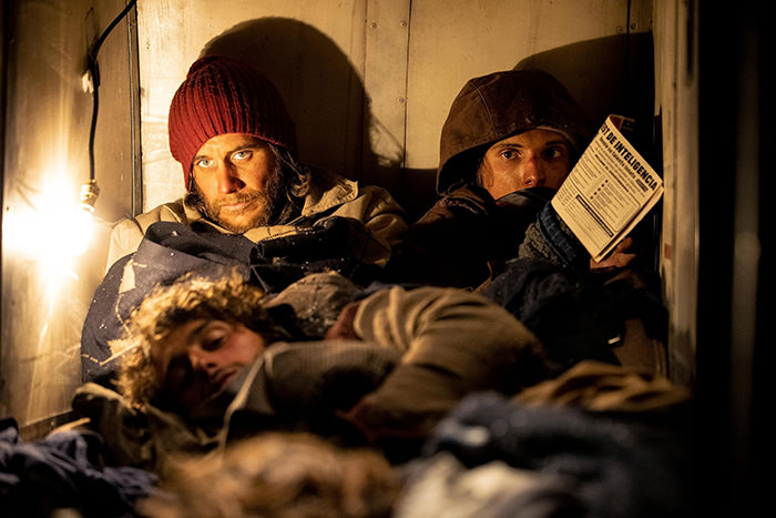 Scene from the Netflix movie "Society of the Snow" showing survivors of the Flight 571 crash in Andes huddling up for warmth inside the plane wreckage.
