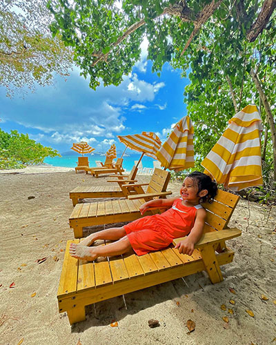 Smiling Journey Castillo resting on a beach chair at the Virgin Islands National Park, her favorite of all national parks she visited as a child, before the age of 3.