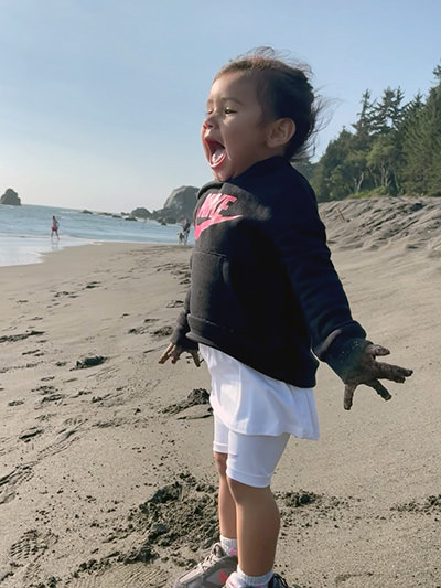 Amazed 3-year-old Journey Castillo with gaping mouth on the beach of the Redwood National Park, one of the 63 U.S. national parks she visited before the age of 3.