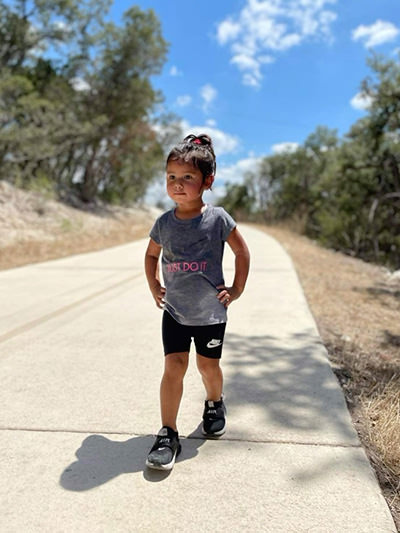 Three-year-old Journey Castillo from San Antonio, Texas, training on a trail for her hiking adventures, dressed in "Just do it" t-shirt, with Nike as her favorite wear.