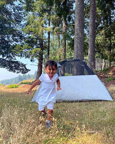 Journey Castillo by the tent at Redwoods National Park, one of 63 national parks in the USA she will visit before the age of 3.