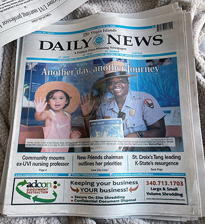 Journey Castillo on the cover of the Virgin Islands Daily News, with a national park ranger.
