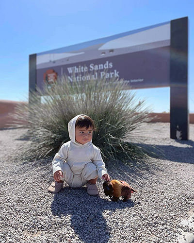 Toddler Journey Castillo with a stuffed buffalo toy at the White Sands National Park, one of the 63 national parks in the United States, all of which she will visit before her third birthday.