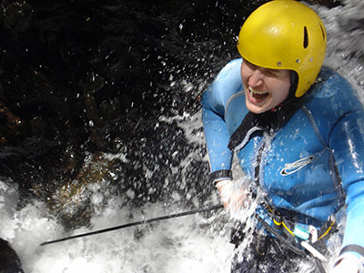 Krista Ann Knutson during a rappelling adventure in New Zealand; the travel blogger thought she was going canoeing, but ended up canyoning due to misunderstanding the tour organizer's words.