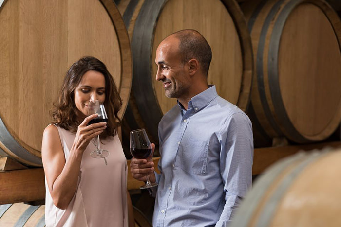 A couple tasting red wine in a cellar during the San Francisco wine tour by Big Bus Sightseeing, GetYourGuide; one of Valentine food gift ideas.